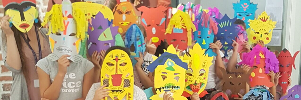 Zdjęcie przedstawia grupę dzieci w kolorowych maskach.