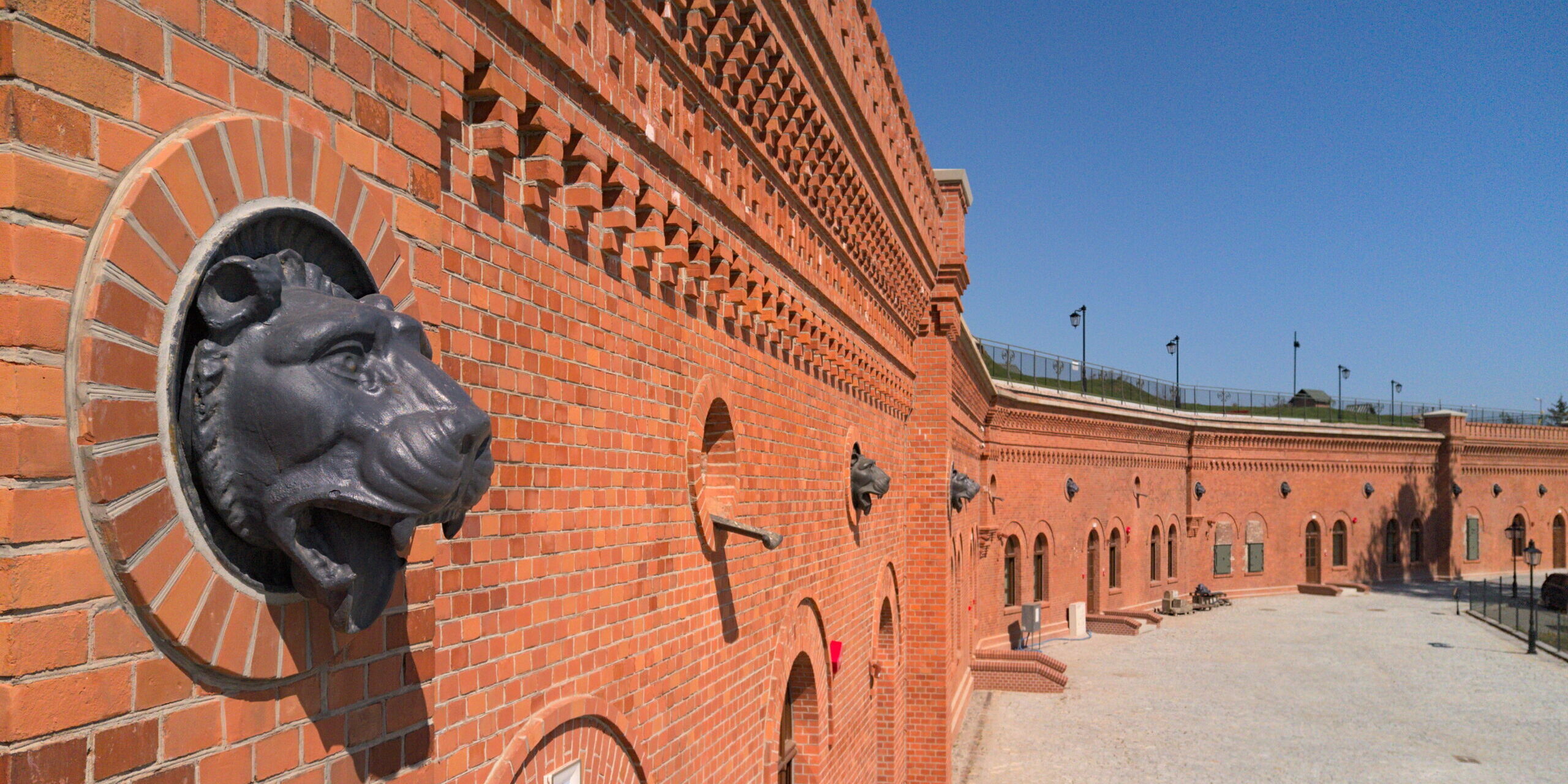 Na zdjęciu rzygacz z głową lwa na fasadzie Muzeum Twierdzy Toruń