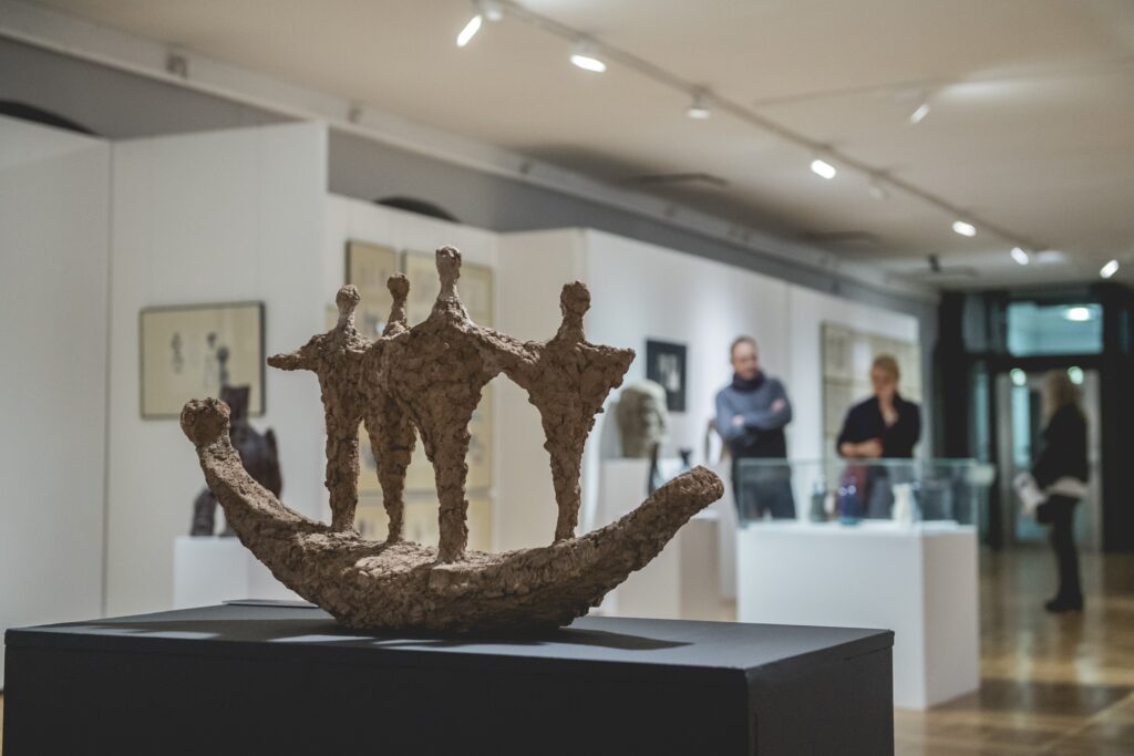 Rzeźba przedstawiająca ludzi na łuku, ceramika, sala wystawowa