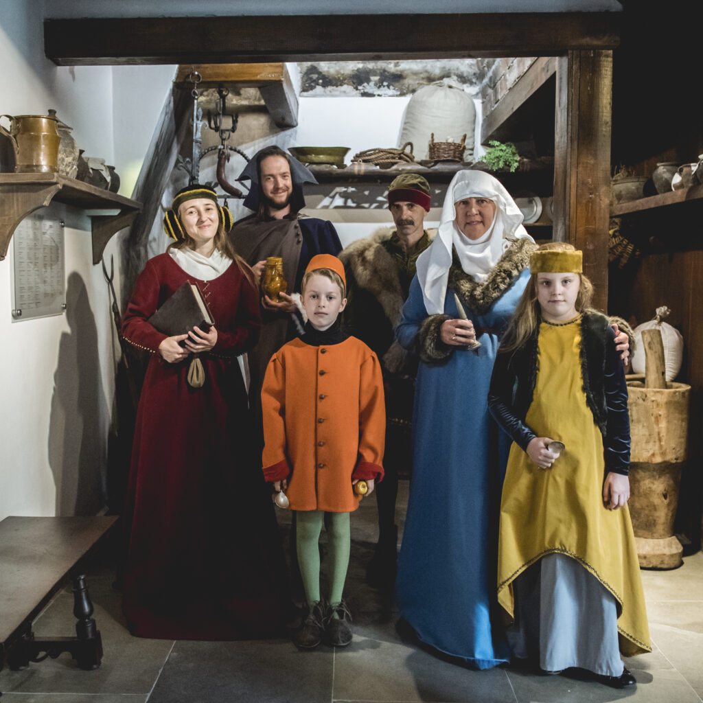 Rodzina w strojak z epoki w średniowiecznych wnętrzach
