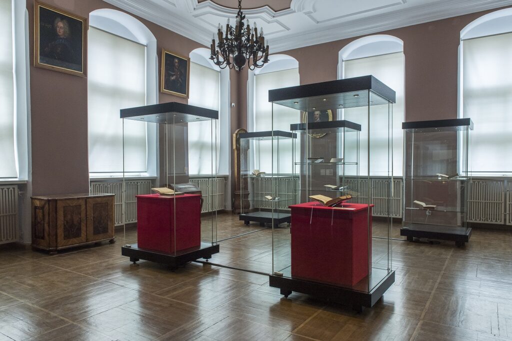 Gabloty ekspozycyjne (wysokie, oświetlone), w którym wyłożono księgi - najstarsze wydania De revolutionibus.