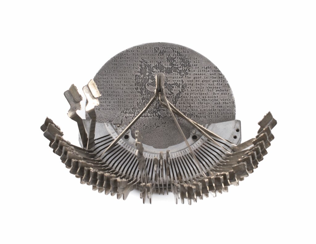 Metalowy medal formą nawiązujący do starej maszyny do pisania.
