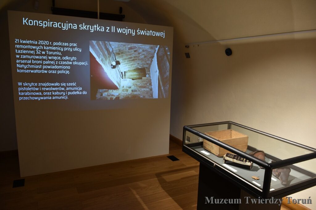 Ekran z nazwą wystawy oraz gablota muzealna